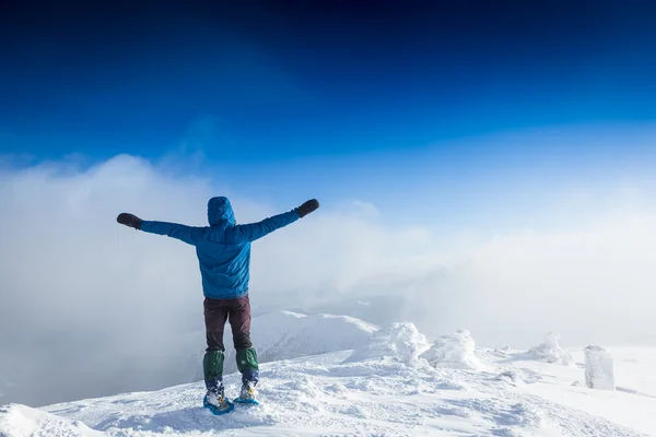 Hombre hipster con las manos levantadas en las montañas — Foto de Stock