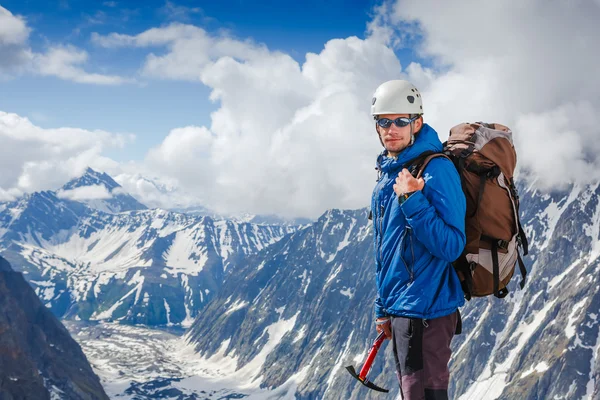 Bergbeklimmer met ijs ax bereikt de top — Stockfoto