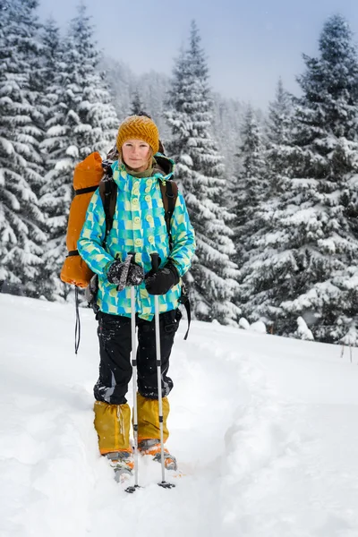 Žena turista v zasněženém lese — Stock fotografie