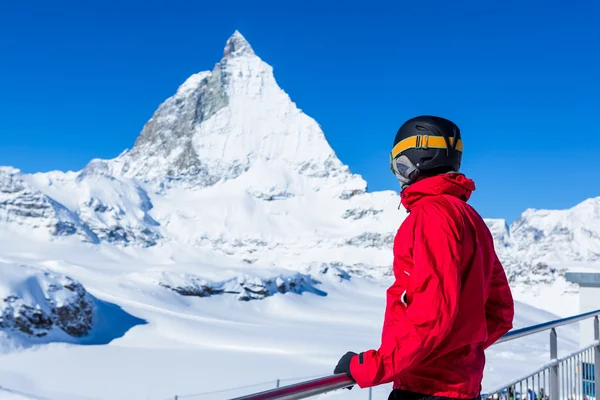 Лыжник смотрит вдаль на заснеженные горы . — стоковое фото