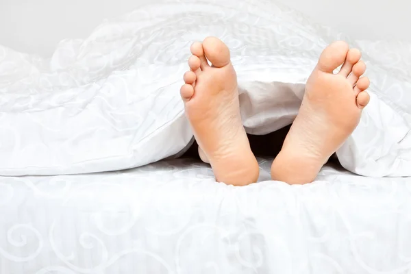 Battaniyenin altında iki ayak — Stok fotoğraf