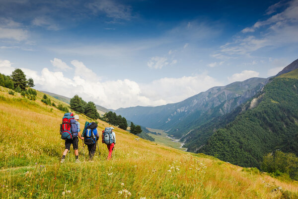 Group of hikers with backpacks walking