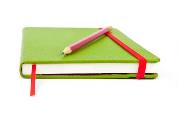 Tužka na zelené Notebook — Stock fotografie