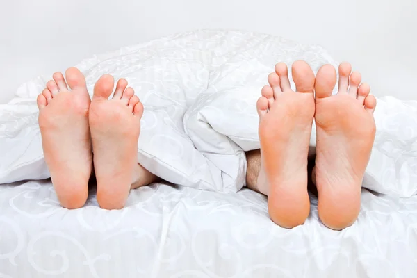Man och kvinna ligga under filt — Stockfoto