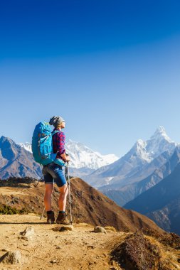 Sırt çantalı bir gezgin Himalaya 'nın arka plandaki dağcılık sporu yaşam tarzı konseptiyle dağlarda yürüyüş yapıyor.
