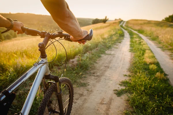 Hombre con bicicleta montando carretera rural. concepto de viaje en bicicleta —  Fotos de Stock