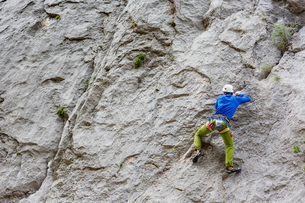 Jeune homme grimpant sur un mur — Photo