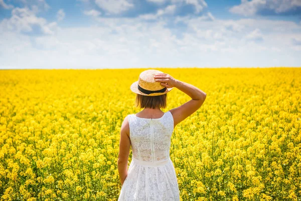 穿着时髦夏装 戴着漂亮帽子 戴着花在田里散步的漂亮女孩 — 图库照片