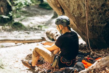 Genç erkek kaya tırmanışçısı yola çıkmaya hazırlanıyor.