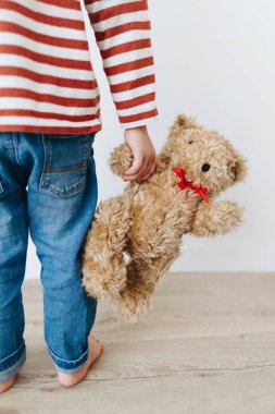 Küçük çocuk en iyi arkadaşını kucağında tutuyor.