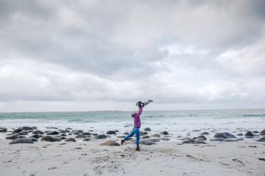 Genç ve çekici anne ve küçük oğlu sahilde eğleniyor.