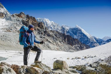 Erkek gezgin Himalayalar 'da dağ yürüyüşünün tadını çıkarıyor. Seyahat, macera, spor konsepti