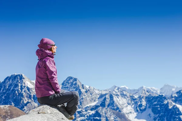 Sırt çantalı gezgin Himalaya Dağlarında dinleniyor.