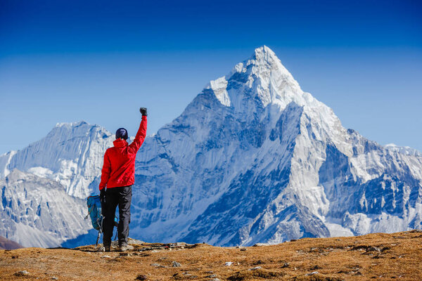 Hiker cheering elated and blissful with arms raised in the sky after hiking. Everest base camp trek. Himalayas, Nepal