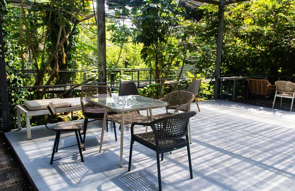 Ahşap verandadaki bahçede masası olan yemek salonu.