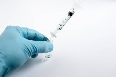 Bir bilim adamının eli cam bir otomatik amplifikatör şişesini kavradı. Sıvı örnek, filtre zarına takılmış bir mikroskopla filtrelenerek HPLC veya LC-MS analizinden önce partikülleri çıkartıyordu..