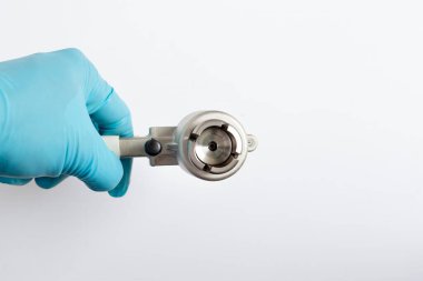 Bir bilim adamının elinde manüel şişe tutarken yakın plan görüntüsü alüminyum kapakları laboratuardaki cam otomatik amplifikatörlere yapıştırmak için gevşek başlığı açıkça gösteriyor..