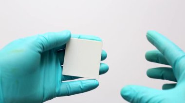 Bir bilim adamı, kimyasal bileşikleri ayırmak için daha büyük bir tabakadan kesilen ince katman kromatografisini (TLC) gösteriyor..