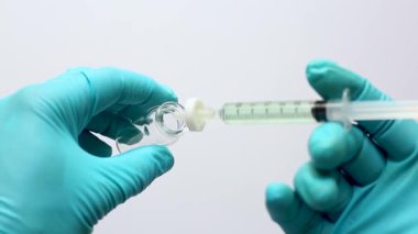 Bir bilim adamının eli cam bir otomatik amplifikatör şişesini kavradı. Sıvı örnek, filtre zarına takılmış bir mikroskopla filtrelenerek HPLC veya LC-MS analizinden önce partikülleri çıkartıyordu..