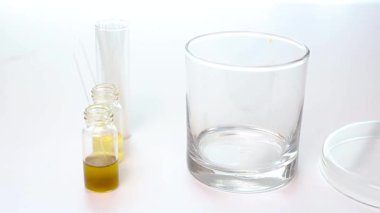 Bir bilim adamı, kimyasal bileşen ayrıştırma analizini başlatmak için bir çözücü tanka benekli ince katman kromatografisi (TLC) plakası yerleştirmek için forseps kullanır..