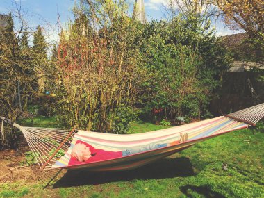 Bahçede bir hamakta yatan bir 30 bir şey sarışın kadın