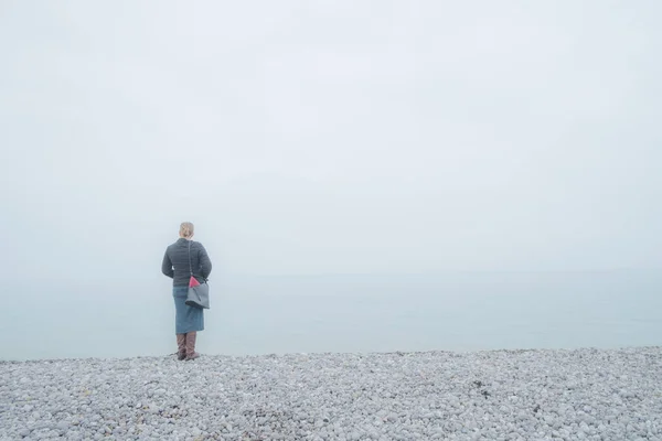 Mujer mirando sobre un mar brumoso — Foto de Stock