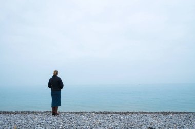 Sisli denize bakan bir kadın