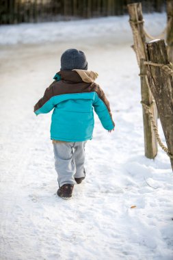 Kışın karla oynayan çocuk. 
