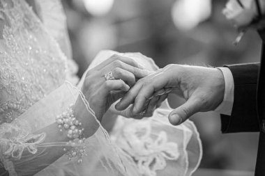 Siyah ve beyaz gelin ve damat evlilik yüzüklerini değiş tokuş ediyor.