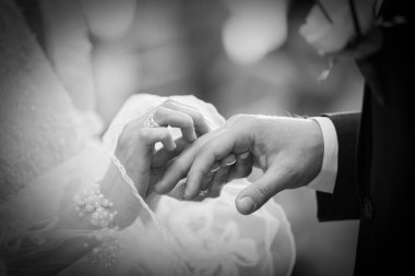 Siyah ve beyaz gelin ve damat evlilik yüzüklerini değiş tokuş ediyor.