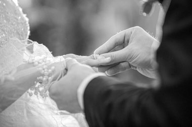 Siyah ve beyaz gelin ve damat evlilik yüzüklerini değiş tokuş ediyor.