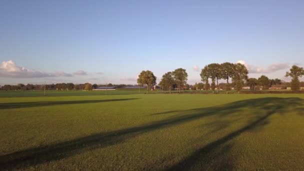 Clipe cinematográfico aéreo: Drone voando sobre um campo de fazenda durante o pôr do sol — Vídeo de Stock