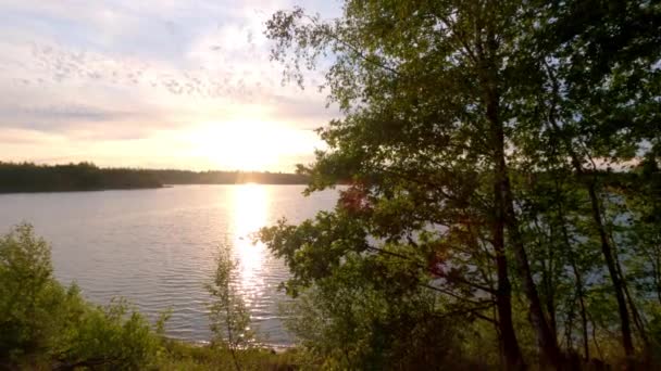 Doğal bir orman gölü üzerinde renkli ve dramatik bir gün batımı — Stok video