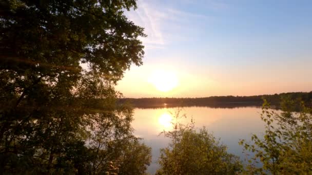 Красочный и впечатляющий закат над природным лесным озером — стоковое видео