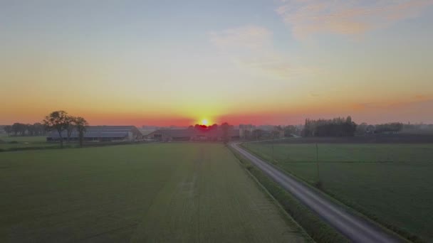 Clipe cinematográfico aéreo, drone voando sobre um campo de fazenda durante o pôr do sol — Vídeo de Stock