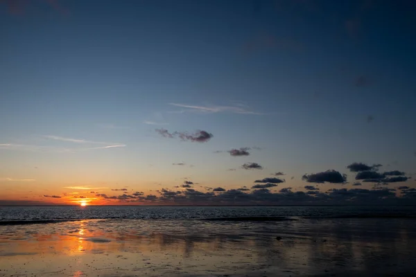 Вигляд сонця, що світить на морі і відбивається на пляжі, на хмарах, які сяють сонцем. Ландшафт — стокове фото