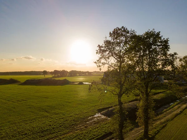 Kleurrijke zonsopkomst of zonsondergang hemel boven een boerderij schot van hoog boven — Stockfoto