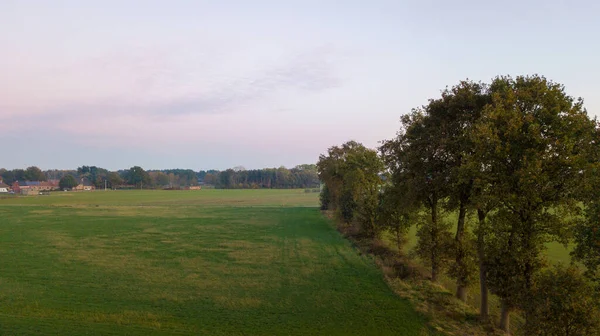 Kleurrijke zonsopkomst of zonsondergang hemel boven een boerderij schot van hoog boven — Stockfoto