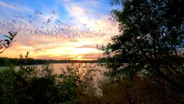 Doğal bir orman gölü üzerinde renkli ve dramatik bir günbatımının zamanı. — Stok video