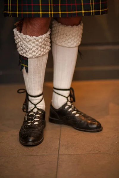 Pés e pernas em saias escocesas, um bagpiper escocês tradicionalmente vestido joga no dia de St. Patricks, trajes de férias para homens — Fotografia de Stock
