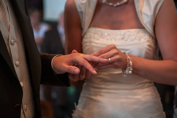 El novio pone un anillo de bodas en el dedo de las novias durante la ceremonia de boda en la iglesia. — Foto de Stock