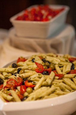 Kurutulmuş domatesli tam buğday ekmekli makarna, siyah ve yeşil zeytin, fesleğen ve parmesanlı beyaz kase.