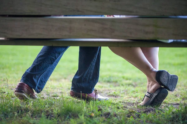 Una giovane coppia innamorata è seduta su una panchina nel parco — Foto Stock