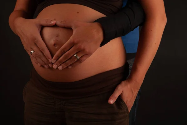 Coppia amorevole con le mani intorno pancia incinta — Foto Stock