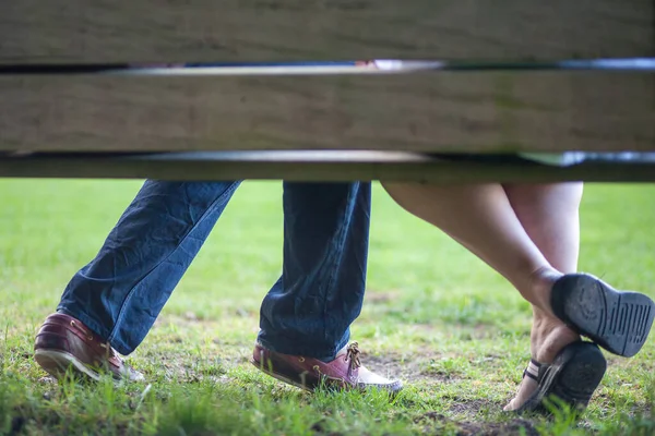 Ett ungt förälskat par sitter på en bänk i parken — Stockfoto