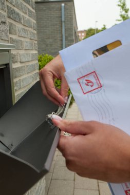 Kadınların el ele tutuştuğu ve posta kutusuna girdikleri ya da çıktıkları fotoğrafları.