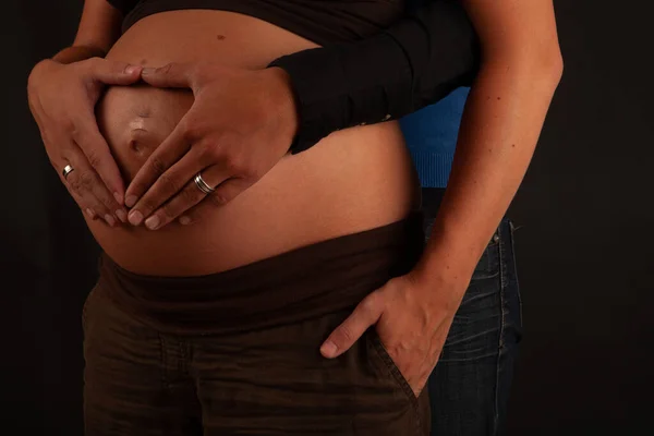 Coppia amorevole con le mani intorno pancia incinta — Foto Stock