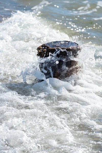 Divide las olas contra un poste de madera en el mar —  Fotos de Stock