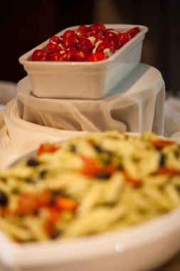 Kurutulmuş domatesli tam buğday ekmekli makarna, siyah ve yeşil zeytin, fesleğen ve parmesanlı beyaz kase.