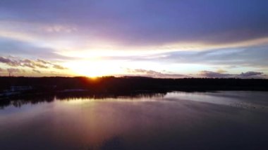 Gün batımında büyük ve büyük bir gölün üzerinde süzülürken